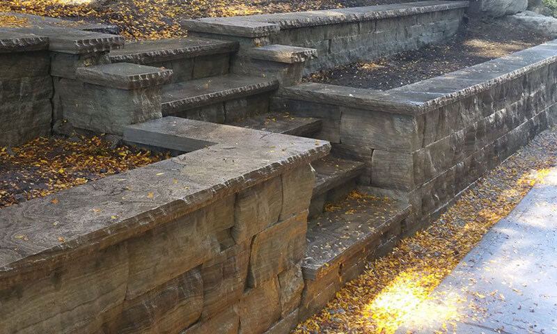 Dry-stacked Eramosa stone planter walls with steps and fresh planting beds