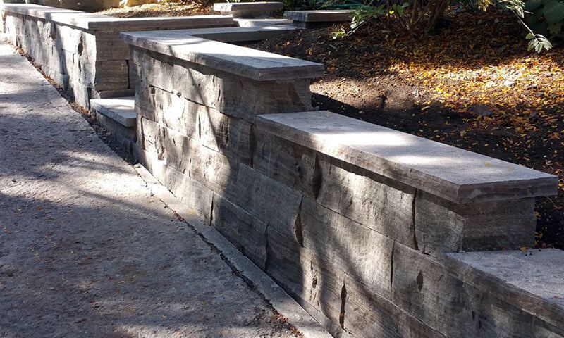 Stepped, capped Eramosa planter walls following a walkway up a gentle slope