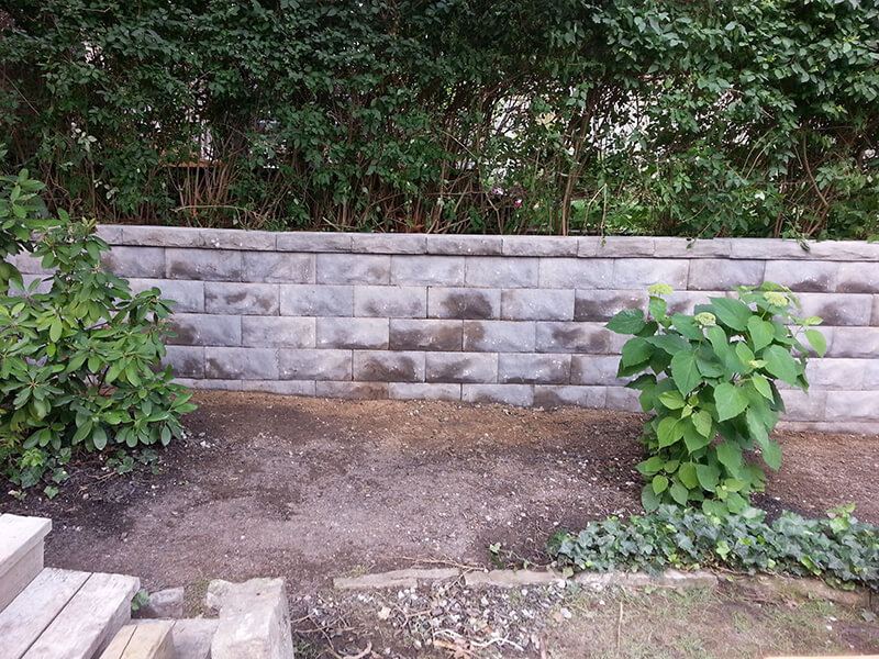Precast block retaining wall with garden shrubs above