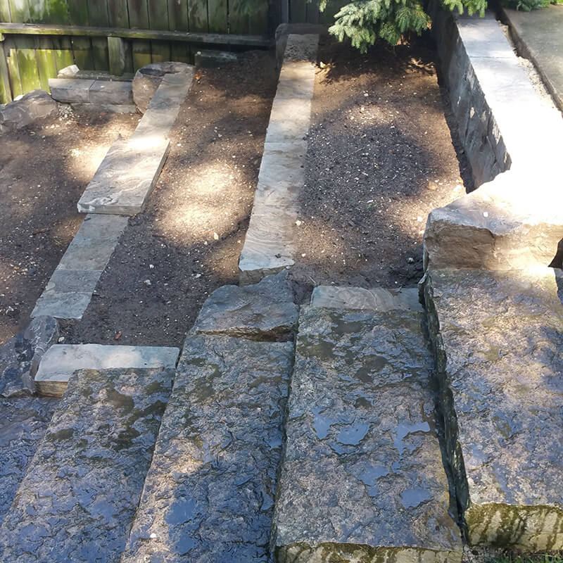 Natural stone steps between terraced garden walls